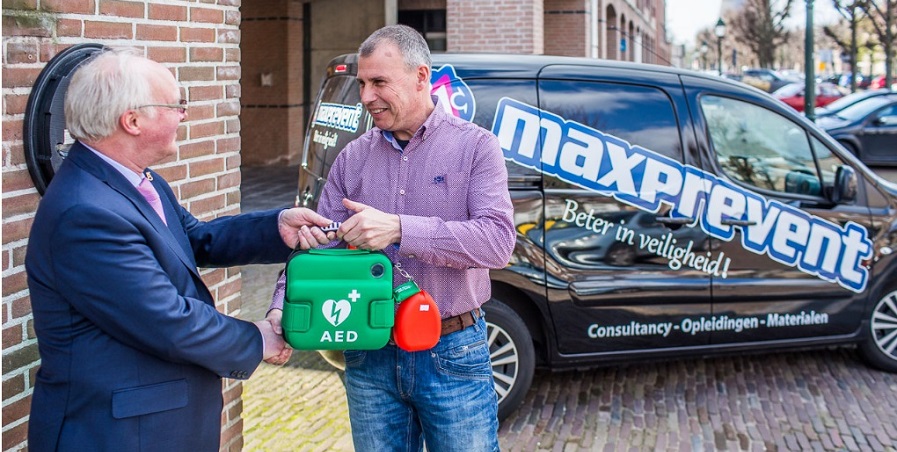Hoe werkt een AED - AED wordt overhandigd aan burgemeester